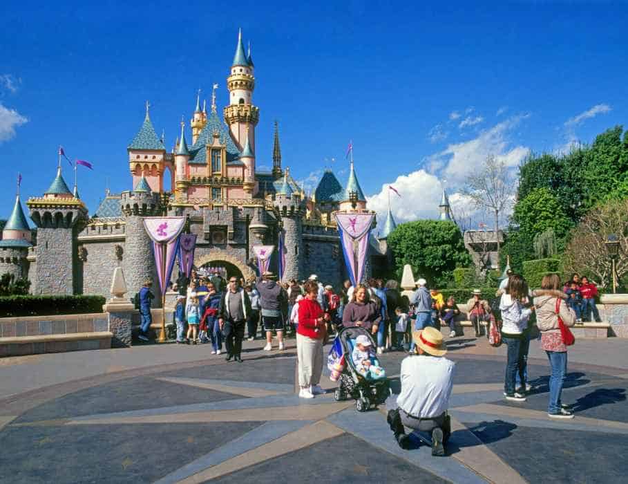 People Wondering Around Outside the Sleeping Beauty Castle at Disney on a Sunny Day